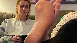 Sexy gamer girl gets her feet massaged and worshipped by a mature woman