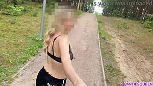 Ξανθιά γυναίκα γυμνάζεται σε εξωτερικούς χώρους στο πάρκο, εκθέτοντας το γυμνό της σώμα και αναπηδώντας το στήθος της